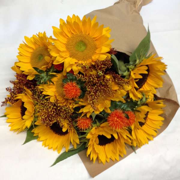 Bouquet of yellow sunflowers wrapped in brown paper