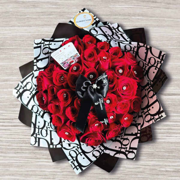 Bouquet of red roses wrapped in black-and-white paper with a black ribbon