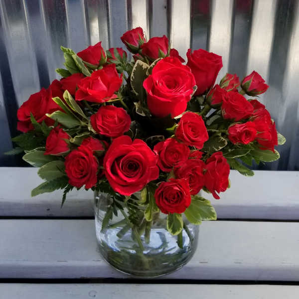 Red roses arranged in a clear glass vase