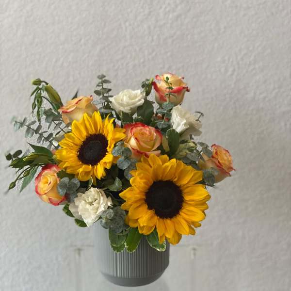 Sunflower and rose bouquet in a gray vase