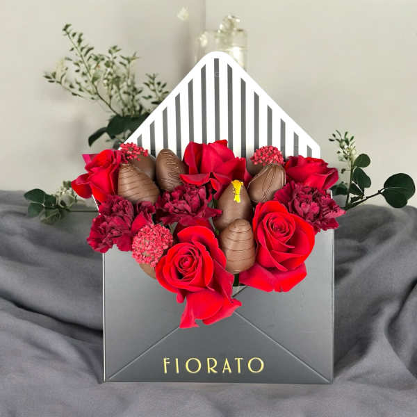 Red roses and chocolates arranged in a black gift box