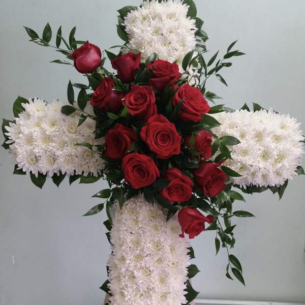 Cross-shaped floral tribute with red roses and white chrysanthemums