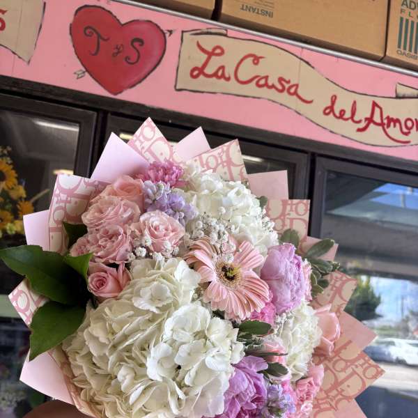 Pink and white mixed bouquet with roses and hydrangeas in decorative wrap