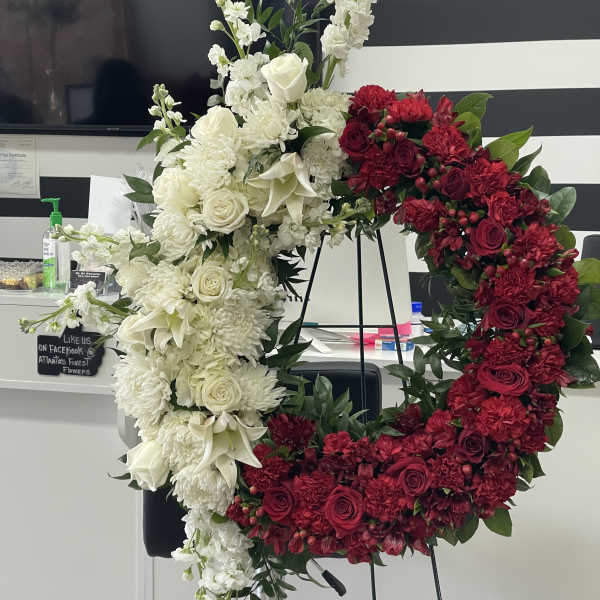 Large red and white floral wreath on a stand