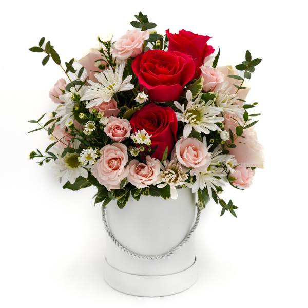 Pink and red roses with white daisies in a white bucket