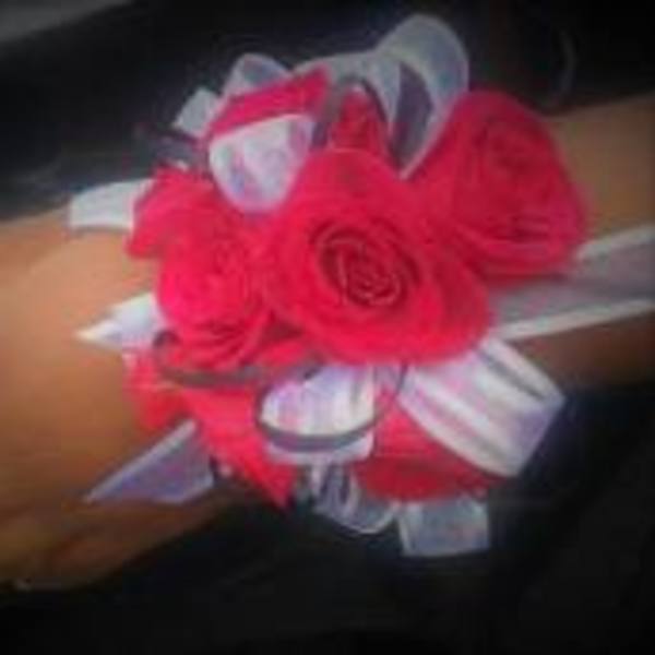 Hand corsage with bright pink roses and white ribbon