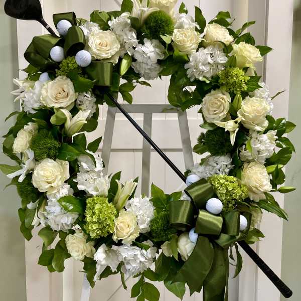 Floral wreath with white roses and lilies on a stand