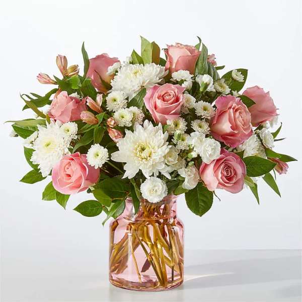 Pink roses and white daisies in a pink glass vase