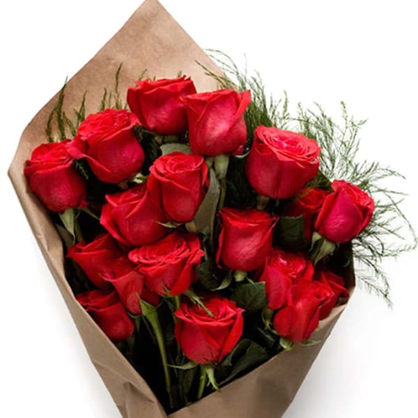 Hand-tied bouquet of red roses wrapped in brown kraft paper