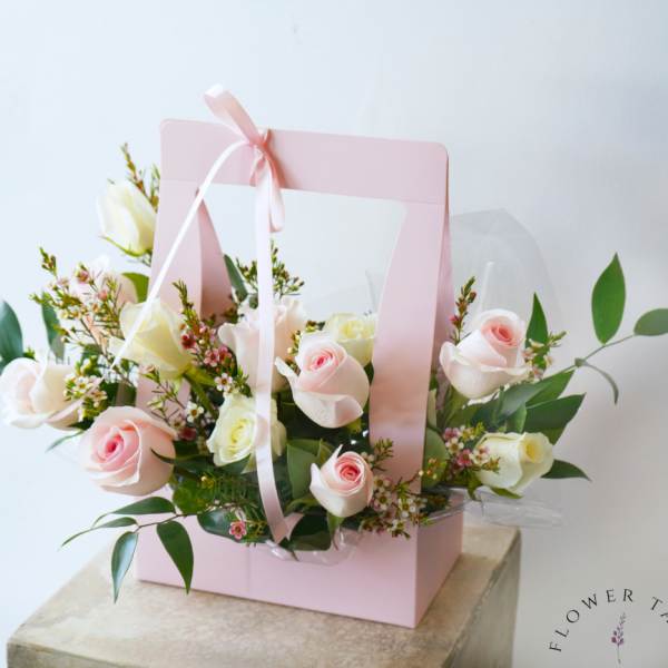 Pink gift box with pale roses and ribbon