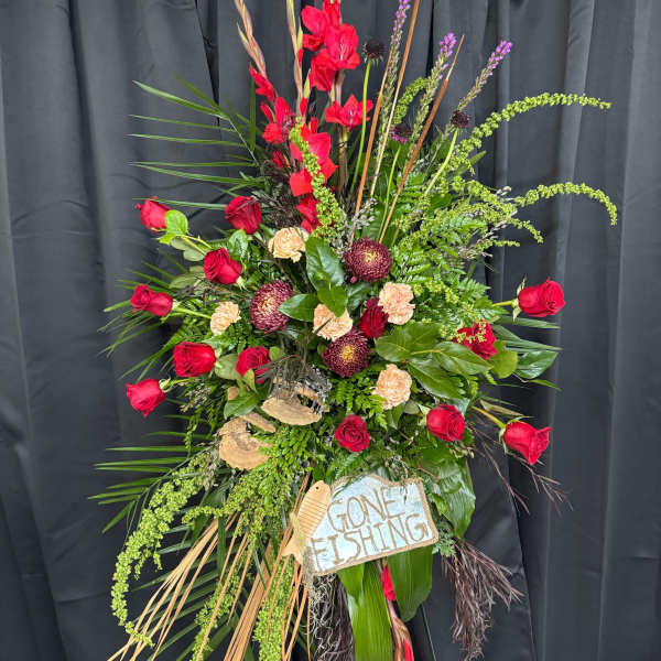Tall floral standing spray with red roses and mixed greenery