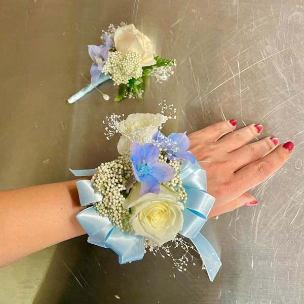 Blue and white floral wrist corsage with ribbon