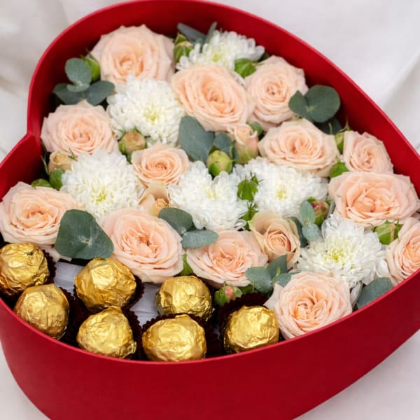 Heart-shaped box with peach roses, white blooms, and gold chocolates