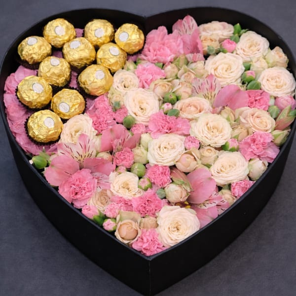 Heart-shaped box of pink and cream flowers with gold-wrapped chocolates