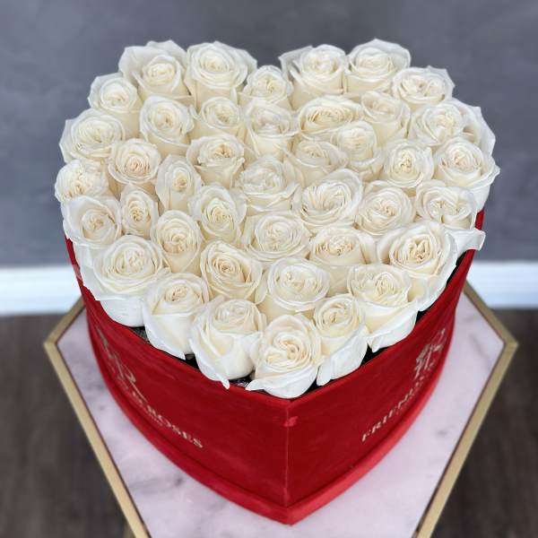 Heart-shaped box filled with white roses
