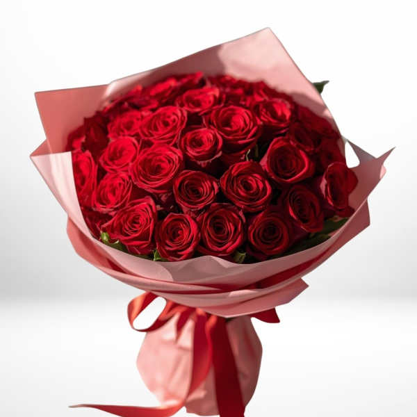Bouquet of red roses wrapped in pink paper with a red ribbon