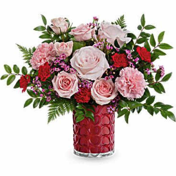 Pink roses and carnations in a red glass vase