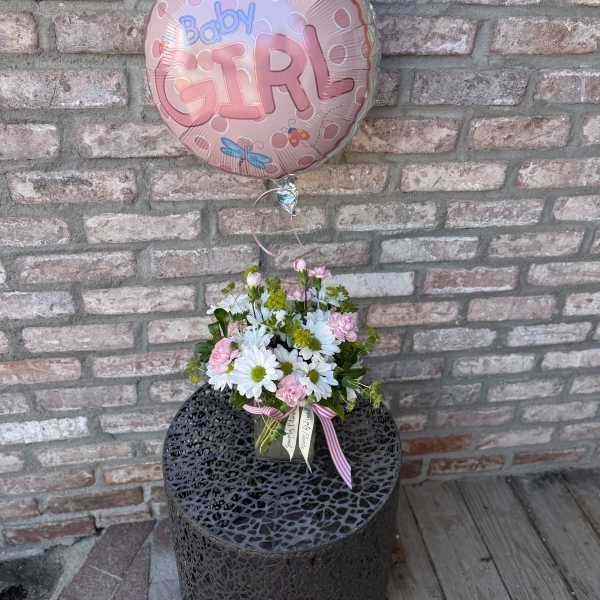 Baby girl balloon with pink and white daisy arrangement in a glass cube vase
