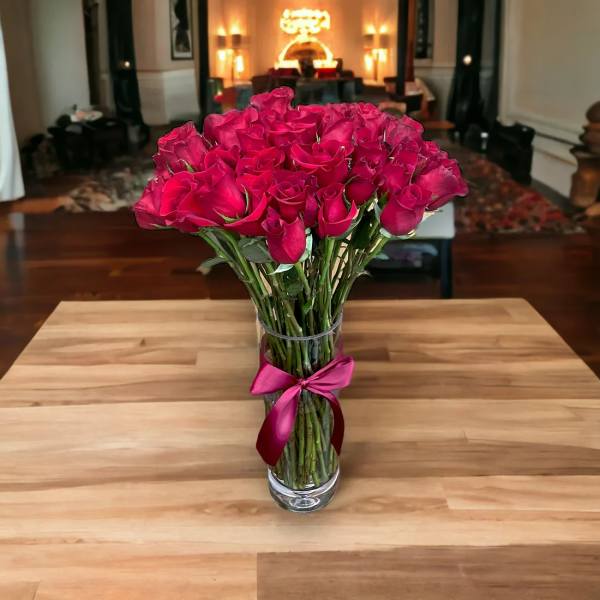 Bouquet of pink roses in a clear glass vase with a ribbon