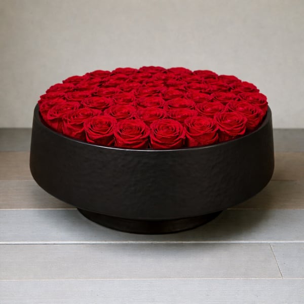 Round black box filled with red roses