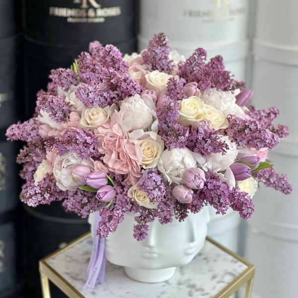 Pink and white bouquet in a white sculpted vase