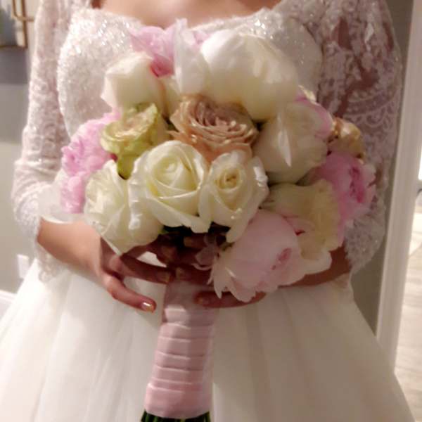 Bride holding a bouquet of white and blush flowers