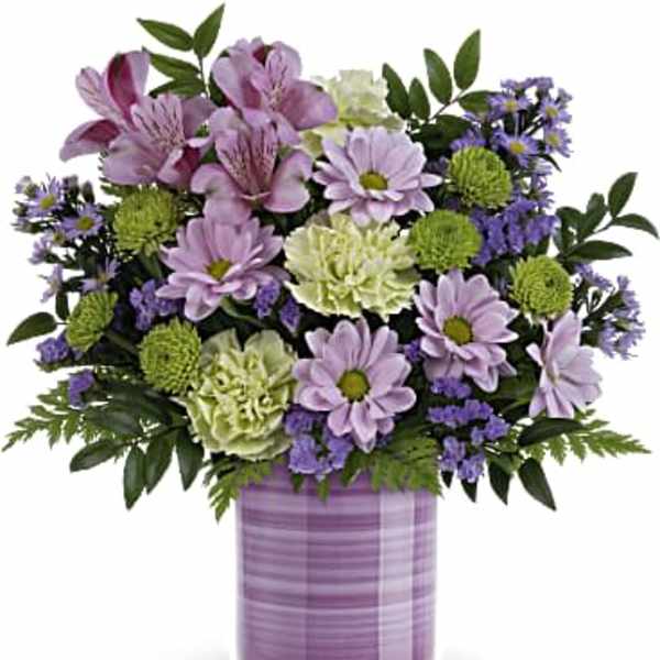 Lavender and green floral arrangement in a purple vase