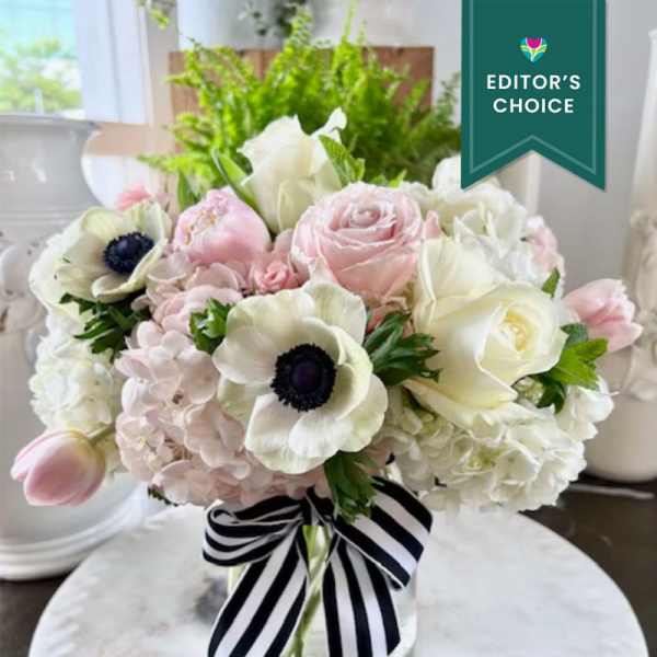 Pink and white bouquet with roses, hydrangeas, and anemones tied with a striped ribbon