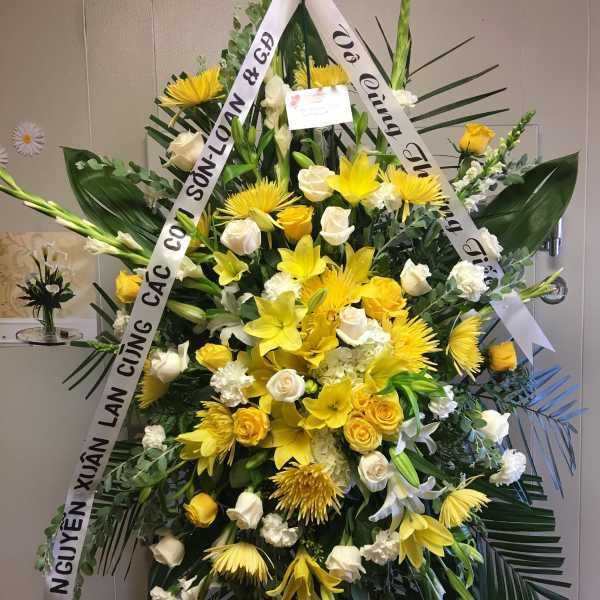 Large yellow and white funeral spray with ribbons