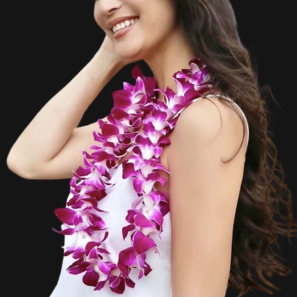 Woman wearing a purple orchid lei over a white dress