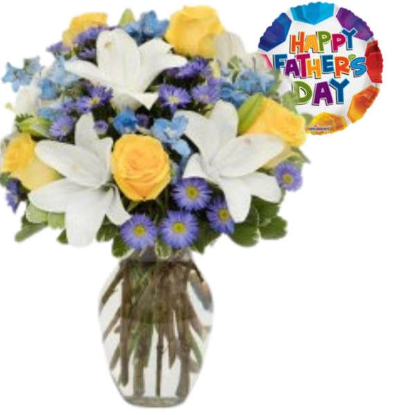 Bouquet of white lilies, yellow roses, and blue flowers in a glass vase with a Father's Day balloon