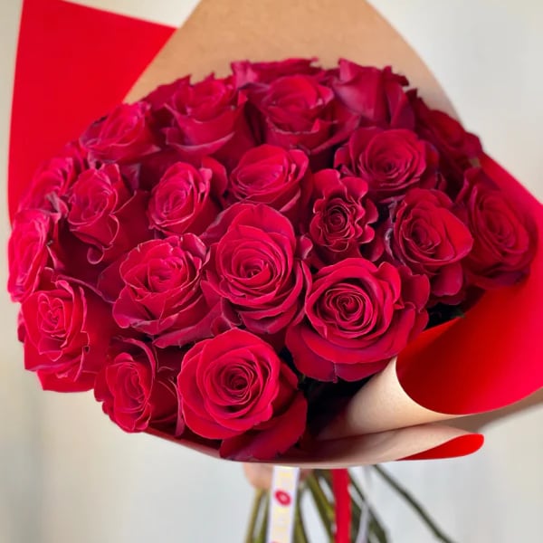 Bouquet of red roses wrapped in tan and red paper