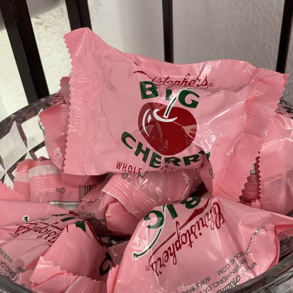 Pink wrapped candy pieces in a clear bowl