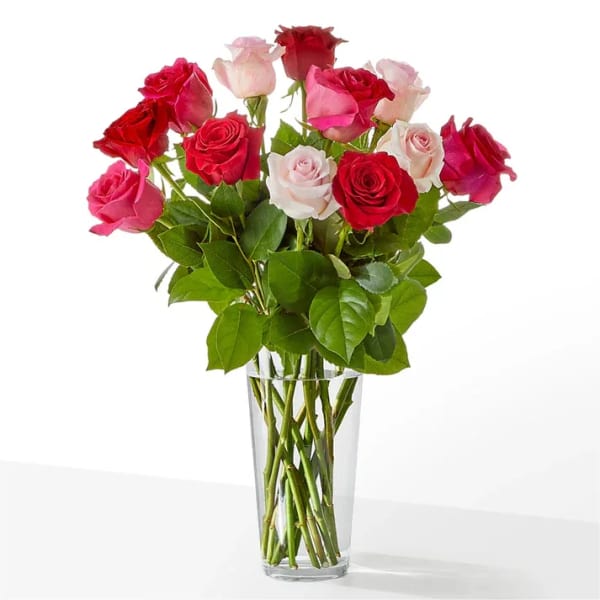 Bouquet of red, pink, and white roses in a clear glass vase