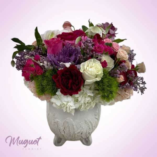 Mixed pink, white, and purple flower arrangement in a decorative vase