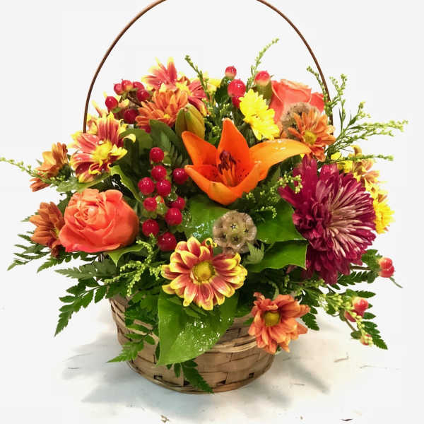 Basket arrangement with orange lilies, roses, and chrysanthemums