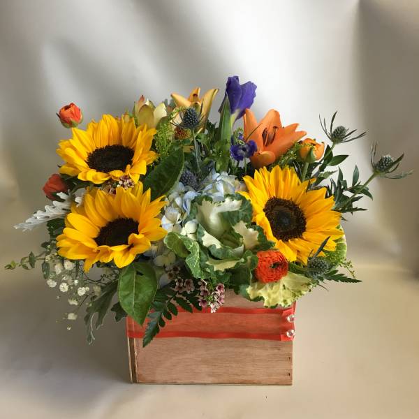 Mixed bouquet with sunflowers, lilies, and hydrangea in a wooden box