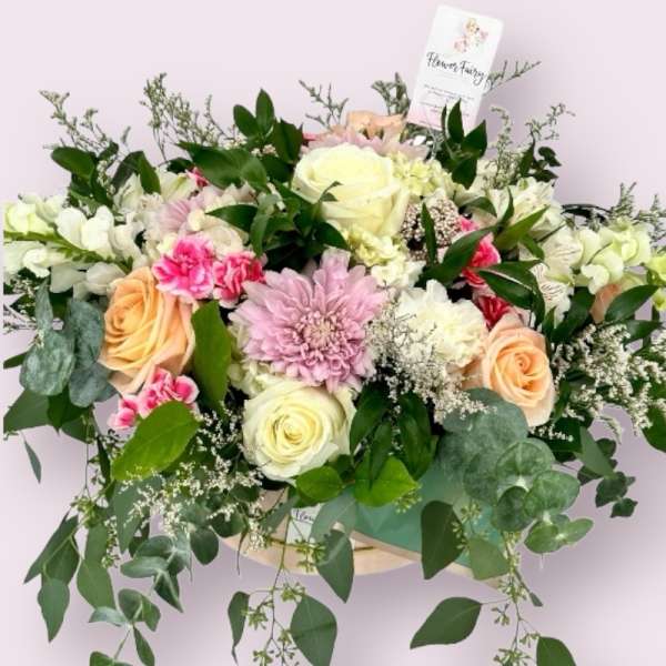 Mixed bouquet of roses, chrysanthemums, and carnations in soft pink and cream tones