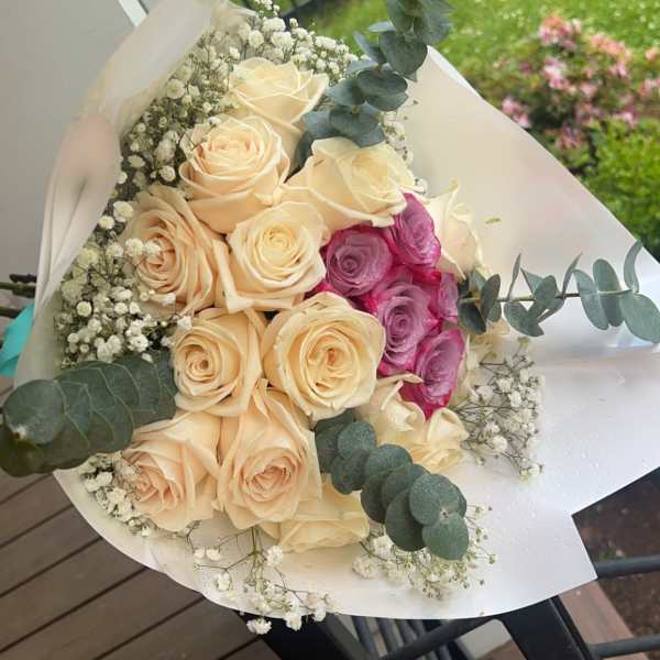 Bouquet of cream and pink roses with baby's breath and eucalyptus