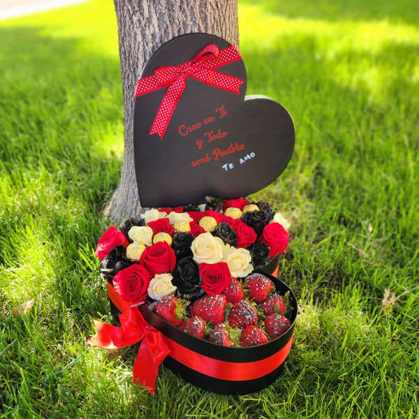 Heart-shaped gift box with red and cream roses and chocolate-covered strawberries