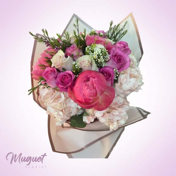 Pink and white bouquet with roses, peonies, and hydrangeas wrapped in paper