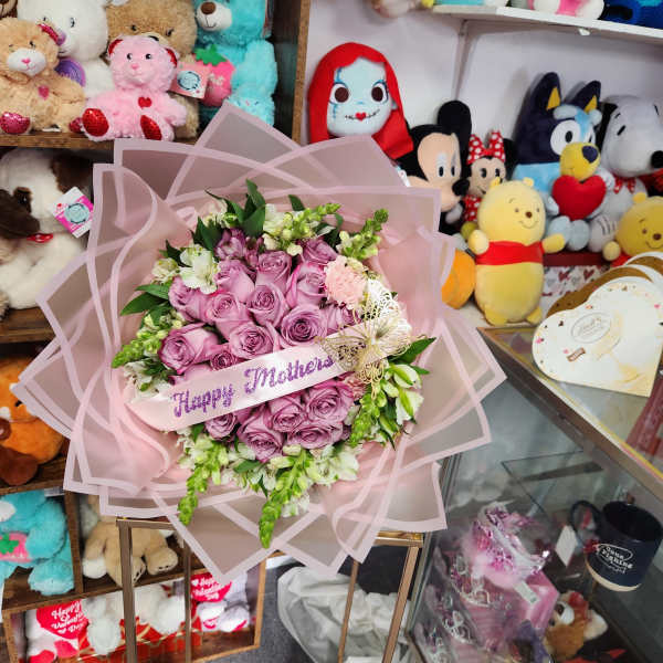 Pink rose bouquet wrapped in pale pink paper with a Happy Mothers ribbon