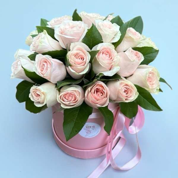 Bouquet of pale pink roses in a pink round box with ribbon