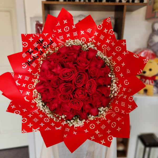 Red rose bouquet wrapped in patterned red paper