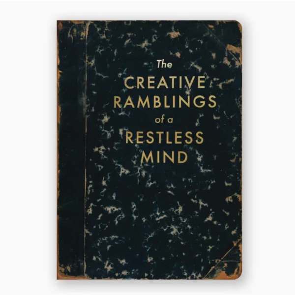 A worn black book cover with gold text reading "The Creative Ramblings of a Restless Mind".