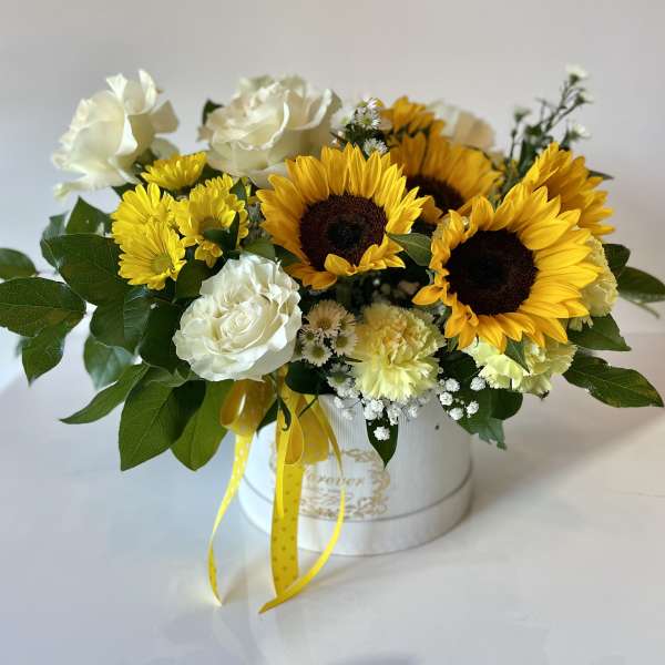 Sunflower and white rose arrangement in a white hatbox with yellow ribbon