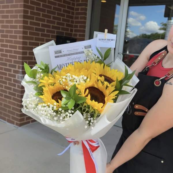 Bouquet of sunflowers with white filler flowers wrapped in white paper