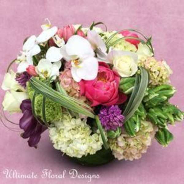 Round bouquet of white orchids, pink roses, and purple flowers