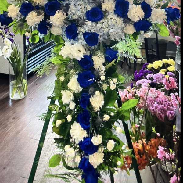 Large blue and white floral cross on an easel