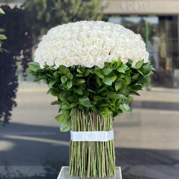 Large bouquet of white roses with a dense green base